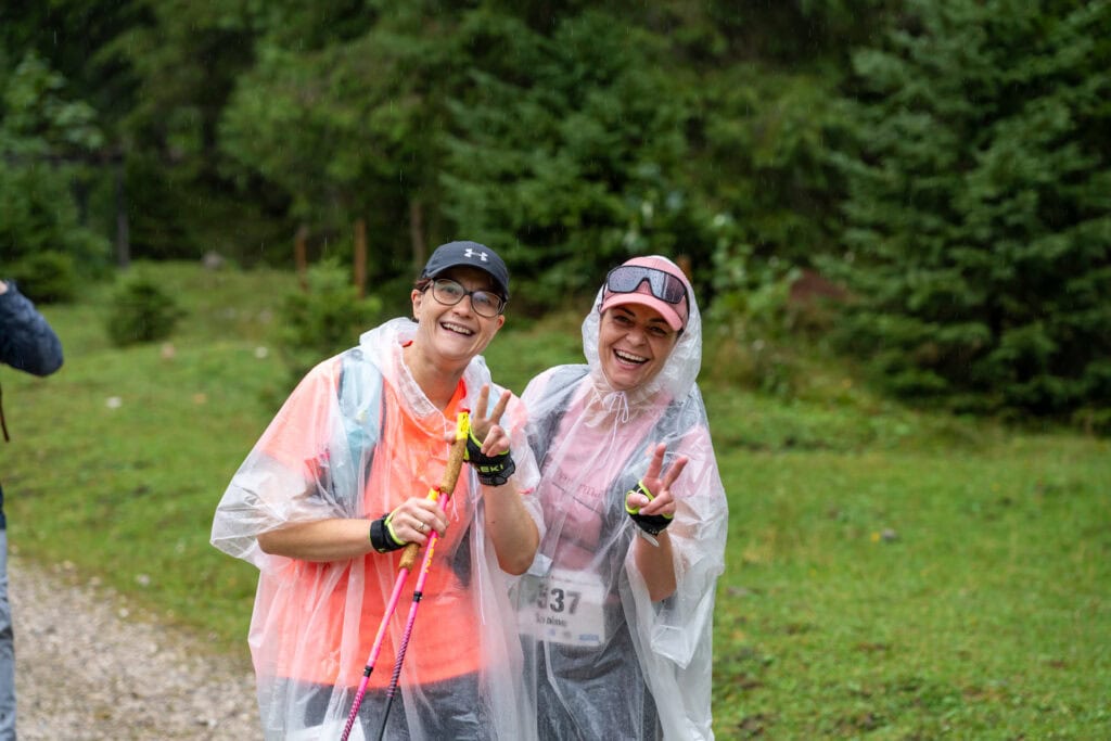 Zwei lächelnde Menschen im Regen mit Ponchos.