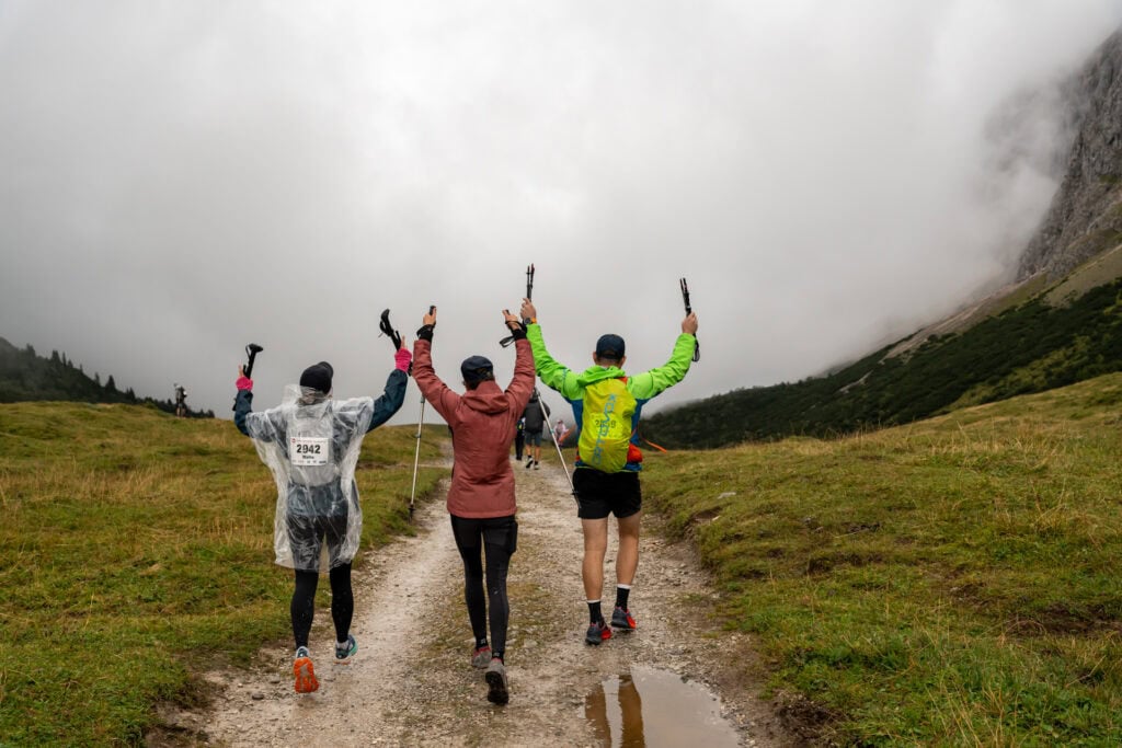 Wanderer auf nebligem Bergpfad mit Stöcken