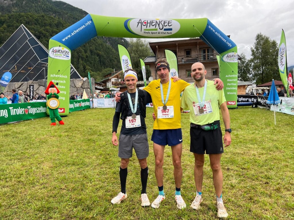 Drei Läufer im Ziel eines Bergmarathons.