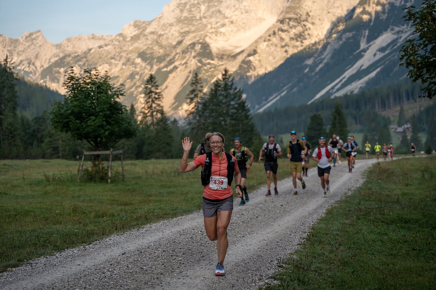 Läufergruppe auf Bergpfad in schöner Landschaft