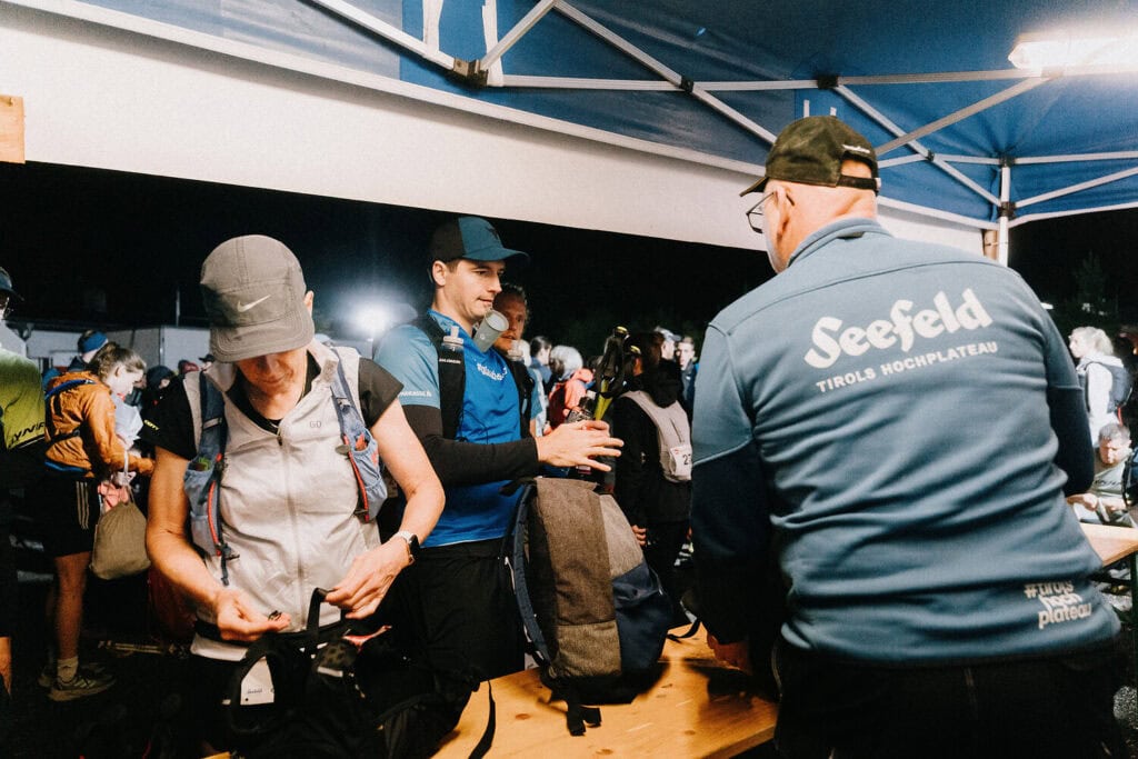 Leute sammeln sich unter einem Zelt bei Nacht.