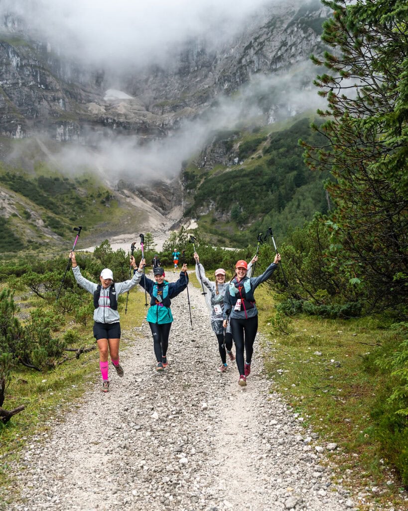 Wandergruppe jubelt auf Bergweg
